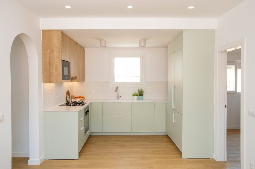 cocina de color verde empolvado con armarios superiores de madera
