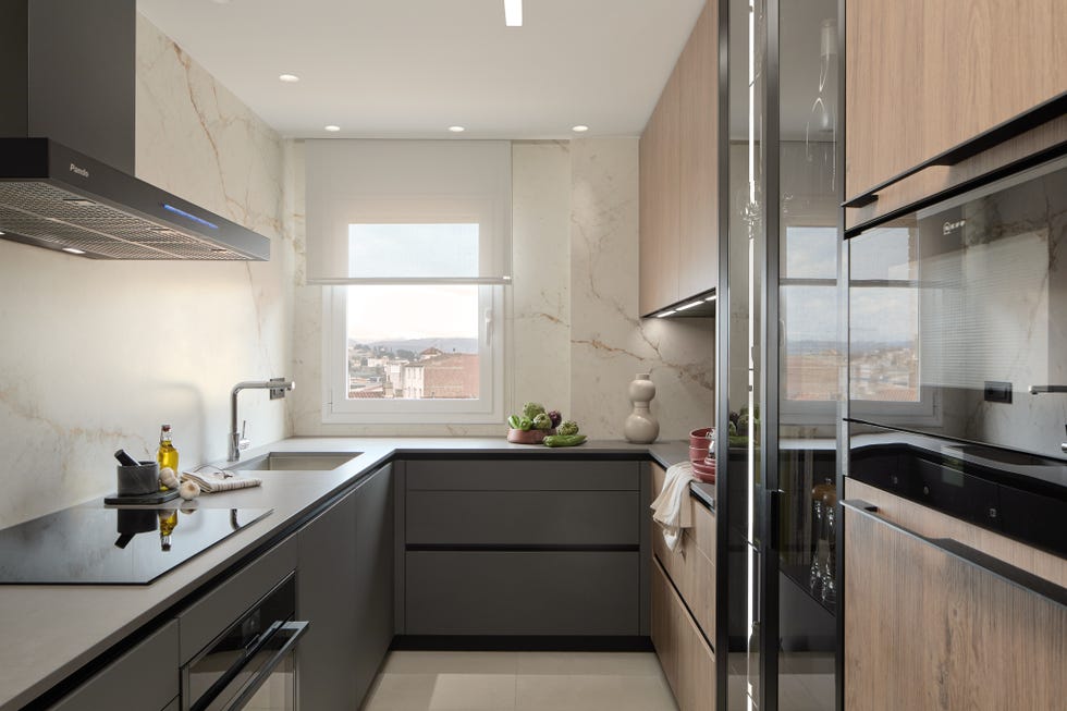 cocina de diseño moderno con armarios grises y de madera y frentes de mármol