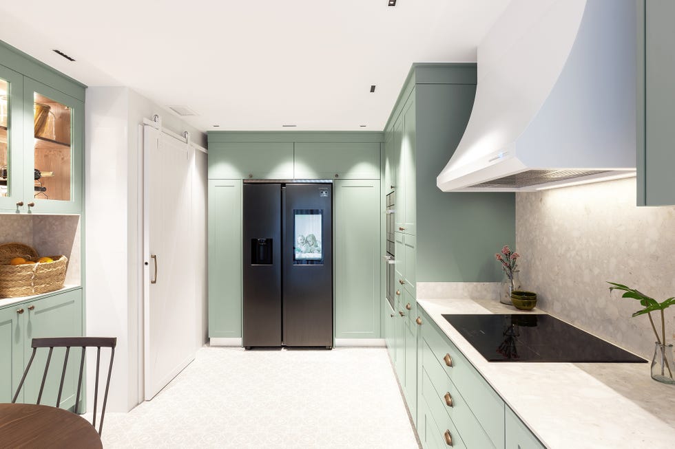 cocina con office de estilo provenzal con armarios de color verde empolvado y nevera de acero inoxidable