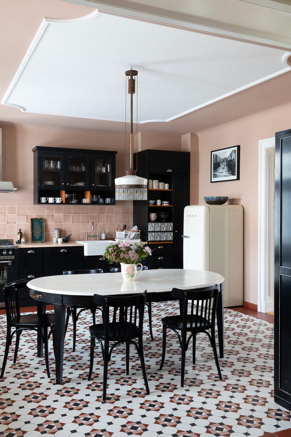 cocina en rosa y muebles en negro con aires vintage