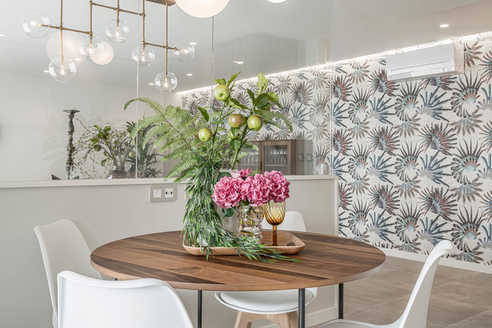mesa de comedor de madera decorada con un centro de flores