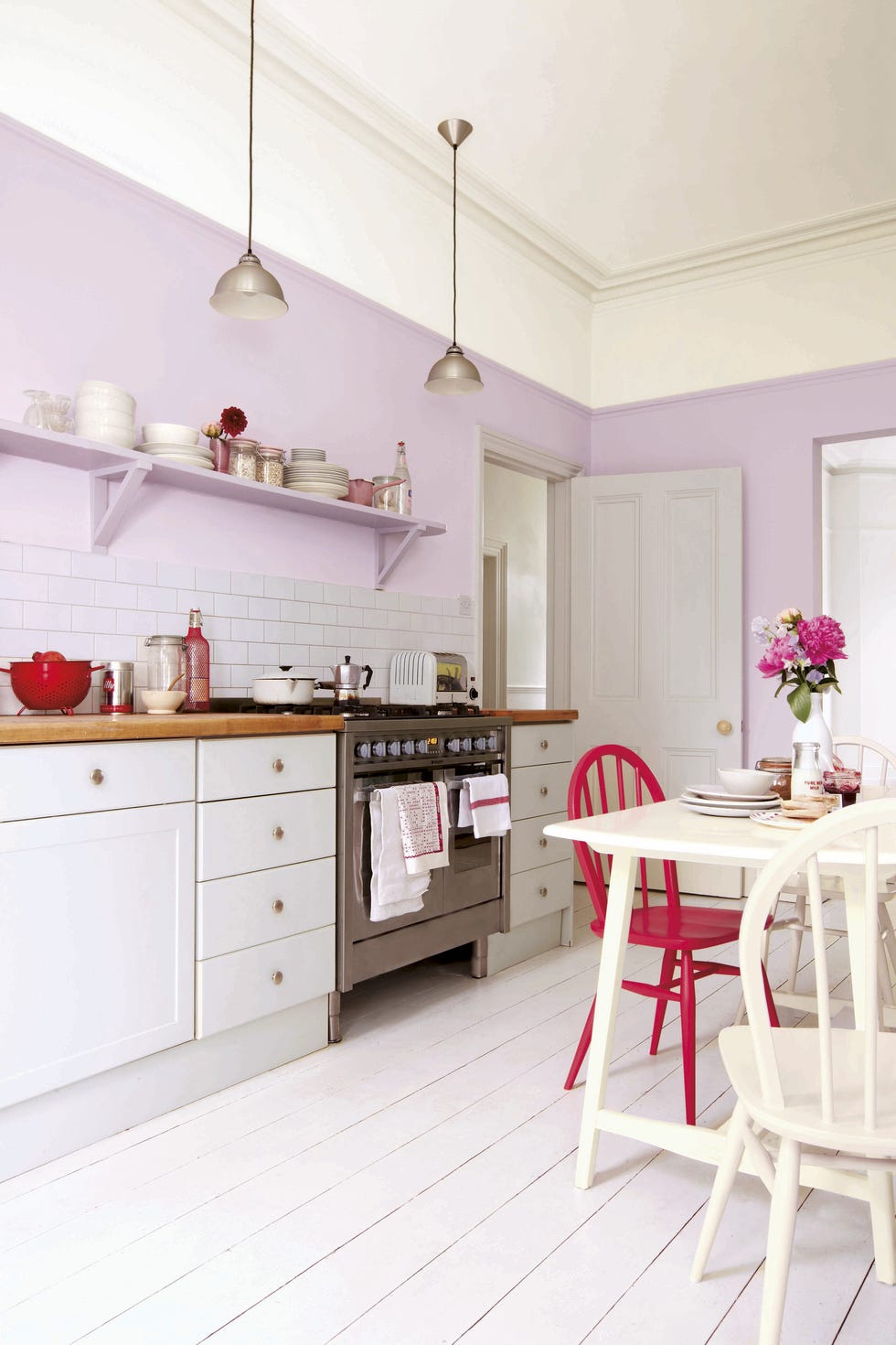 cocina con comedor en colores crema, rojo y lila