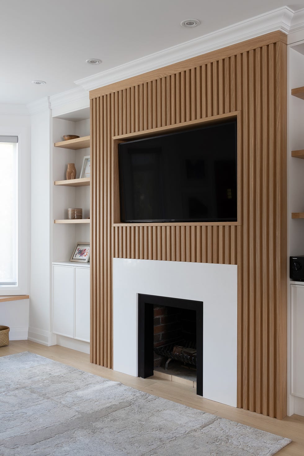 salón escandinavo con panelado de madera en la chimenea