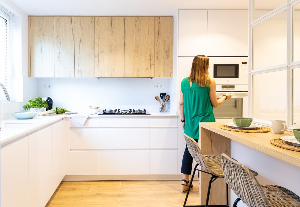 cocina semi abierta diseñada en blanco con armarios y cajones sin tiradores