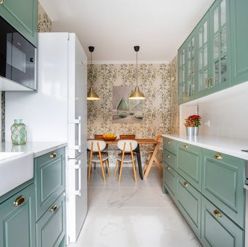 Cocina con armarios verdes y papel pintado con motivos botánicos cocina con armarios verdes y papel pintado con motivos botánicos