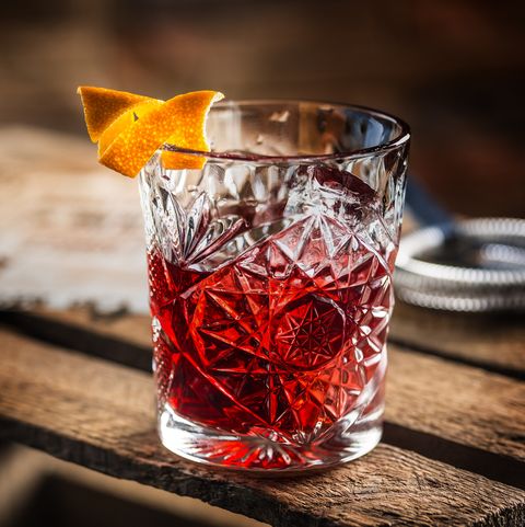 cocktail negroni on a old  wooden board drink with gin, campari martini rosso and orange
