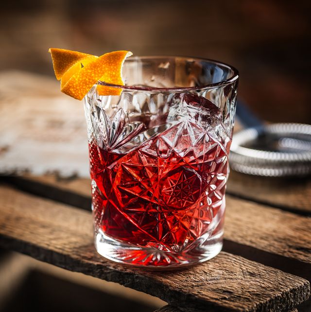cocktail negroni on a old  wooden board drink with gin, campari martini rosso and orange