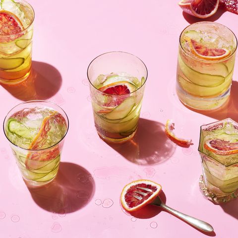 cocktails with fruit garnish on pink background