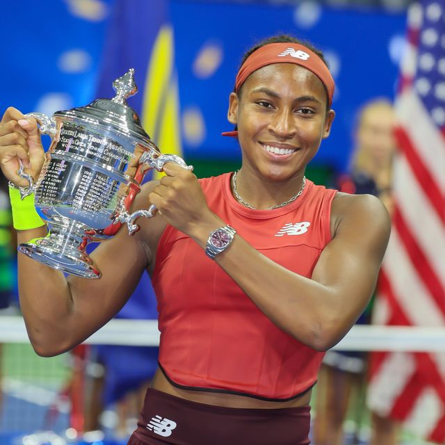 coco gauff holding up her trophy and smiling at the us open