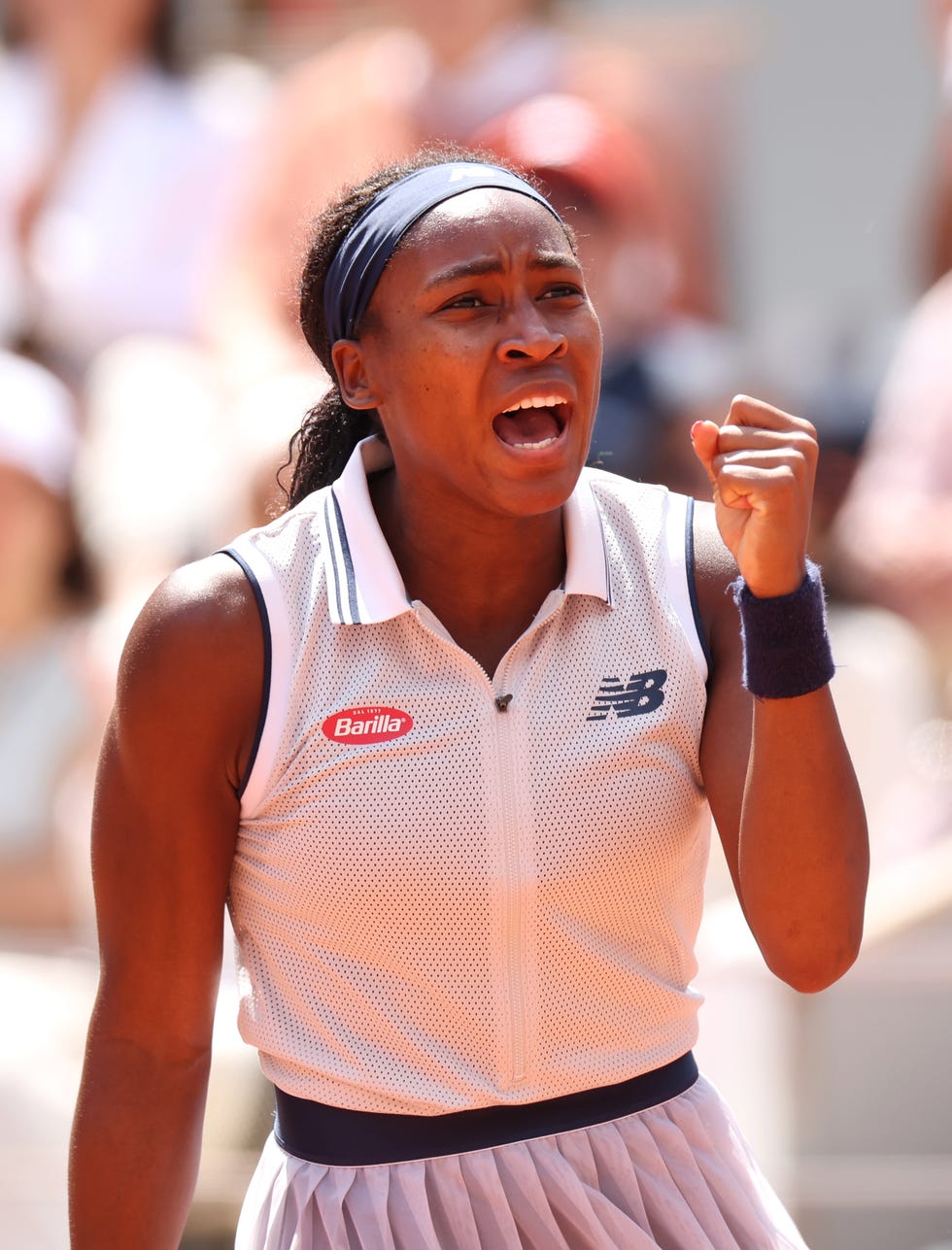 coco gauff making a celebratory gesture with her left arm and screaming during a tennis match