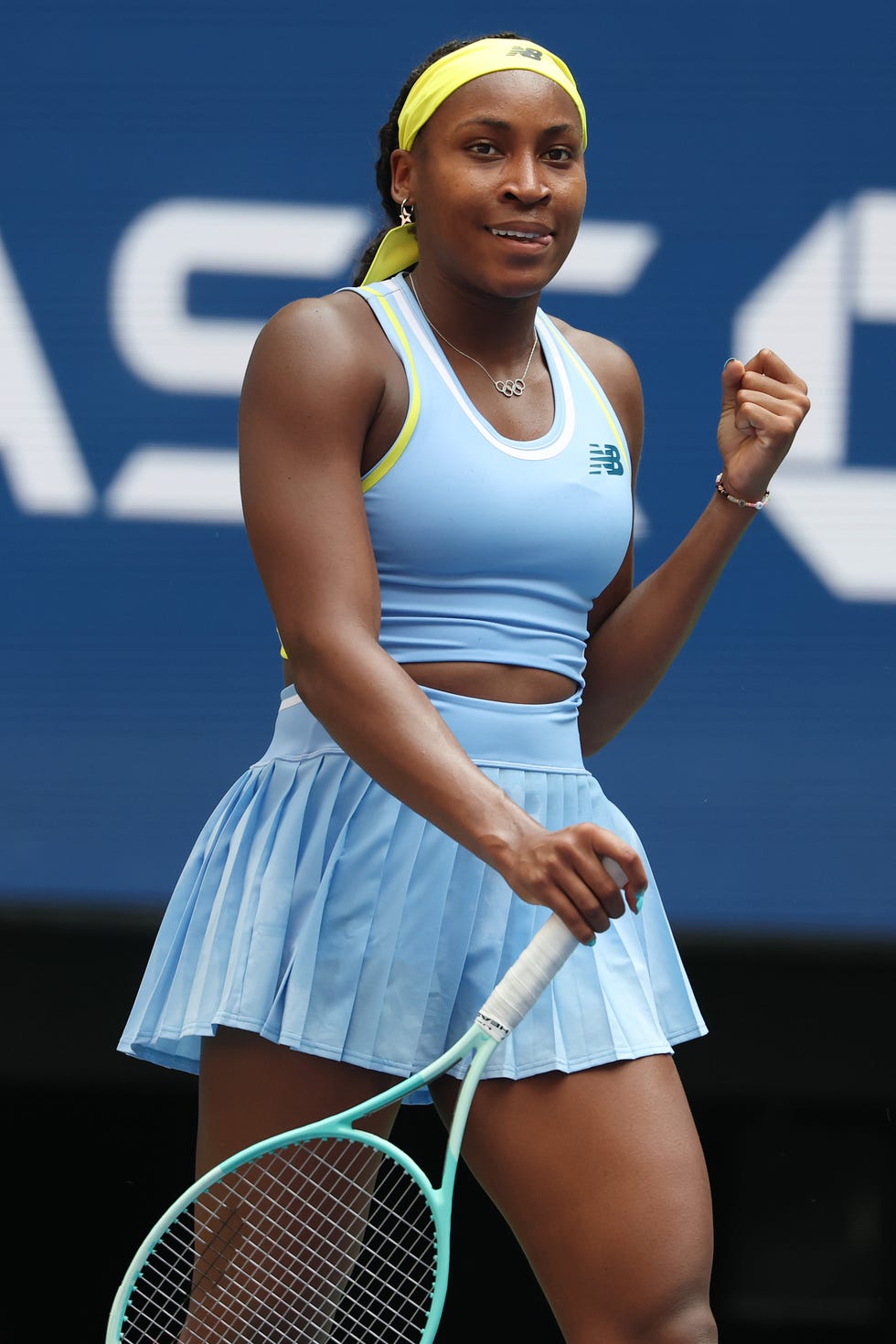 coco gauff smiles and raises her left arm in celebration as she wins a tennis match at the us open