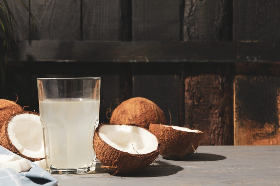 coconut and water on wooden background, space for text tropical fruit