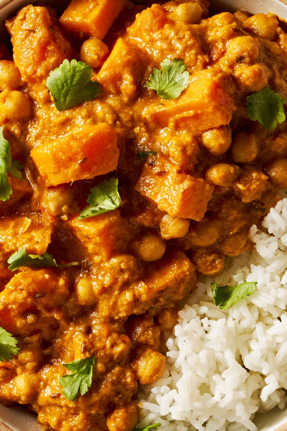 creamy orange coconut chickpea and sweet potato curry served with rice and topped with cilantro
