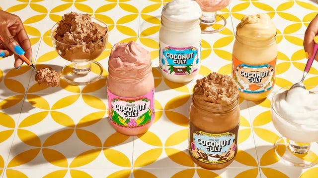 various jars of coconut cult yogurt displayed with servings in bowls