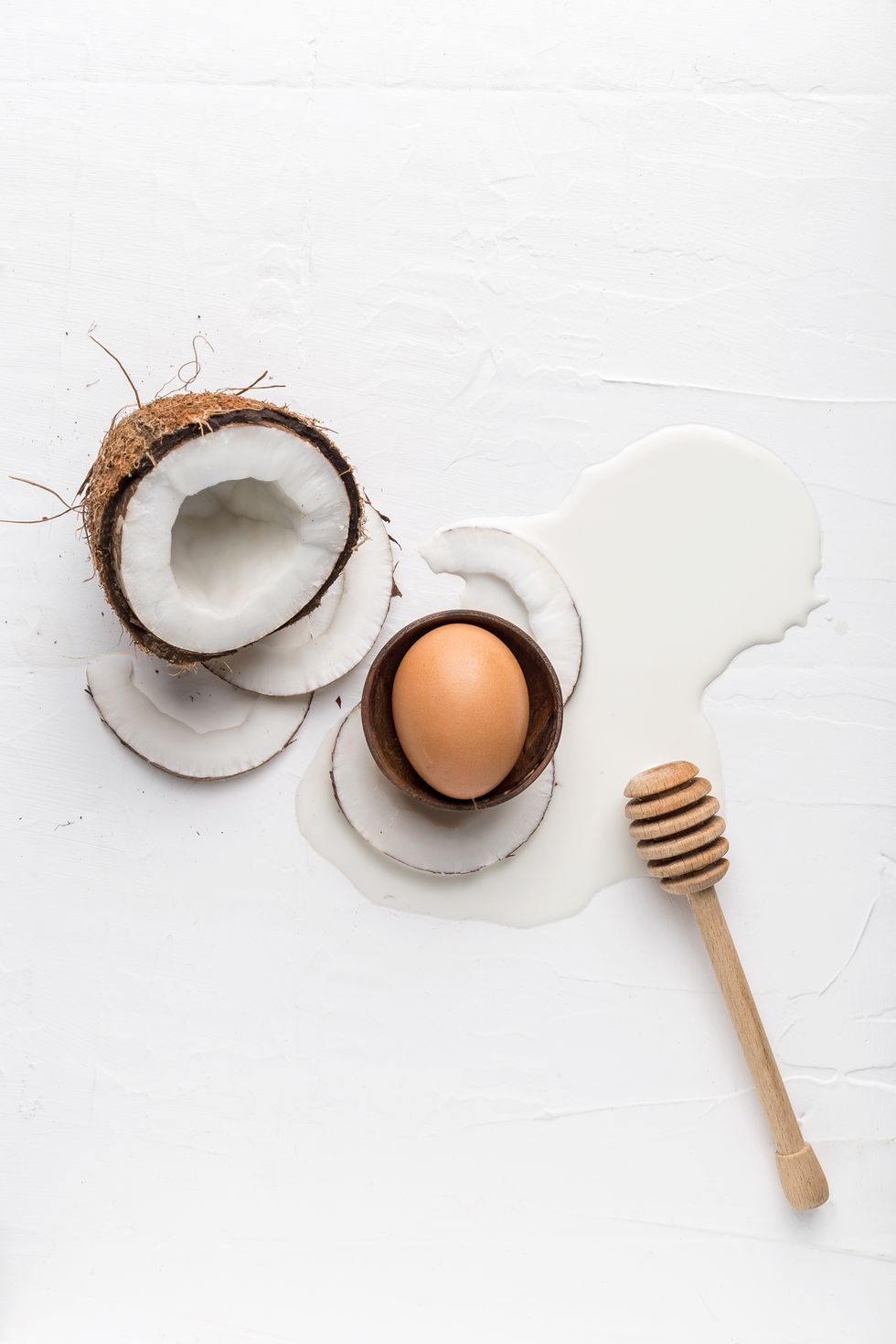 Coconut, egg and fresh milk on a white background, top view
