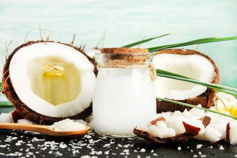 coconut milk glass jar with nuts and oil bottles, fresh coconut flakes