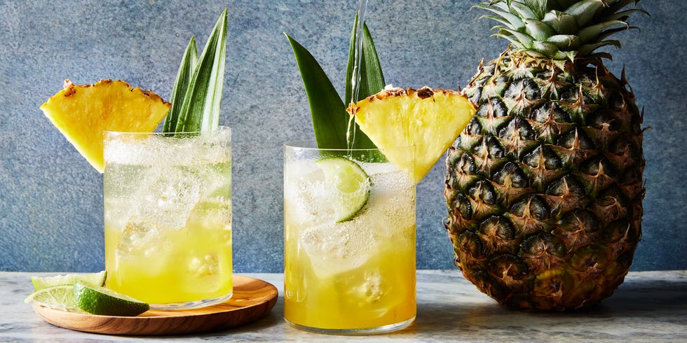 coconut pineapple spritz with a pineapple wedge and pineapple leaf garnish