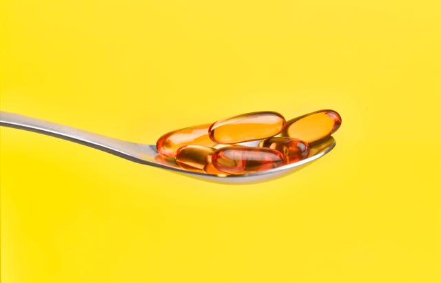 cod liver oil capsules on spoon