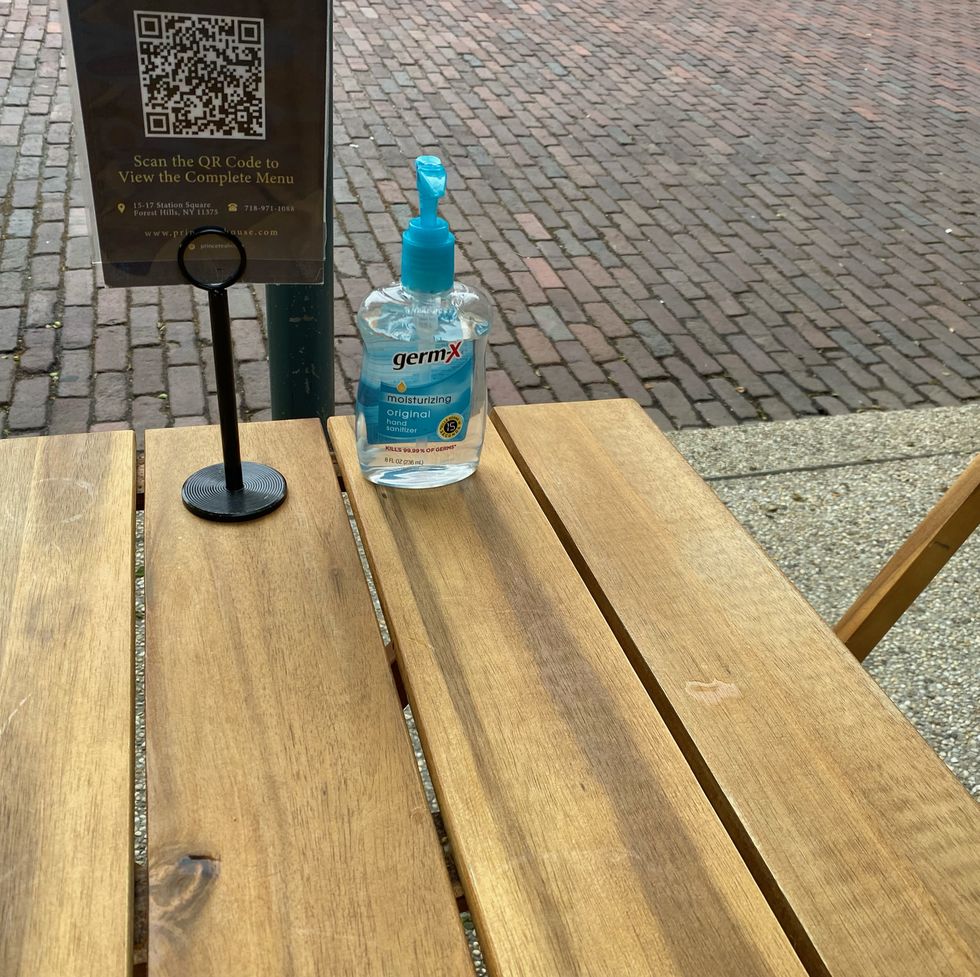 qr code for full menu and sanitizer on table outside station house restaurant, forest hills, queens, ny