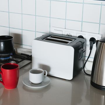 coffee is brewed in a turk on a gas stove, on fire. making coffee for breakfast. a turk for making turkish coffee, in the kitchen at home or in a hostel. there is a bright mug next to it. do it yourself. home life.