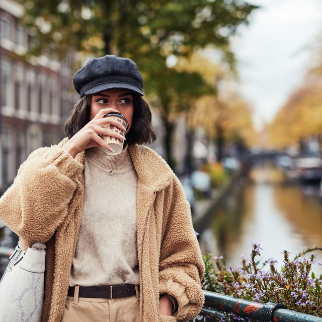 vrouw drinkt op de gracht in amsterdam een koffie