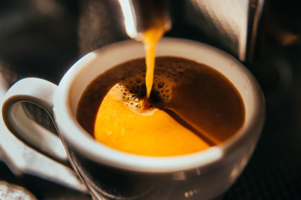 The coffee machine pours a shot of espresso
