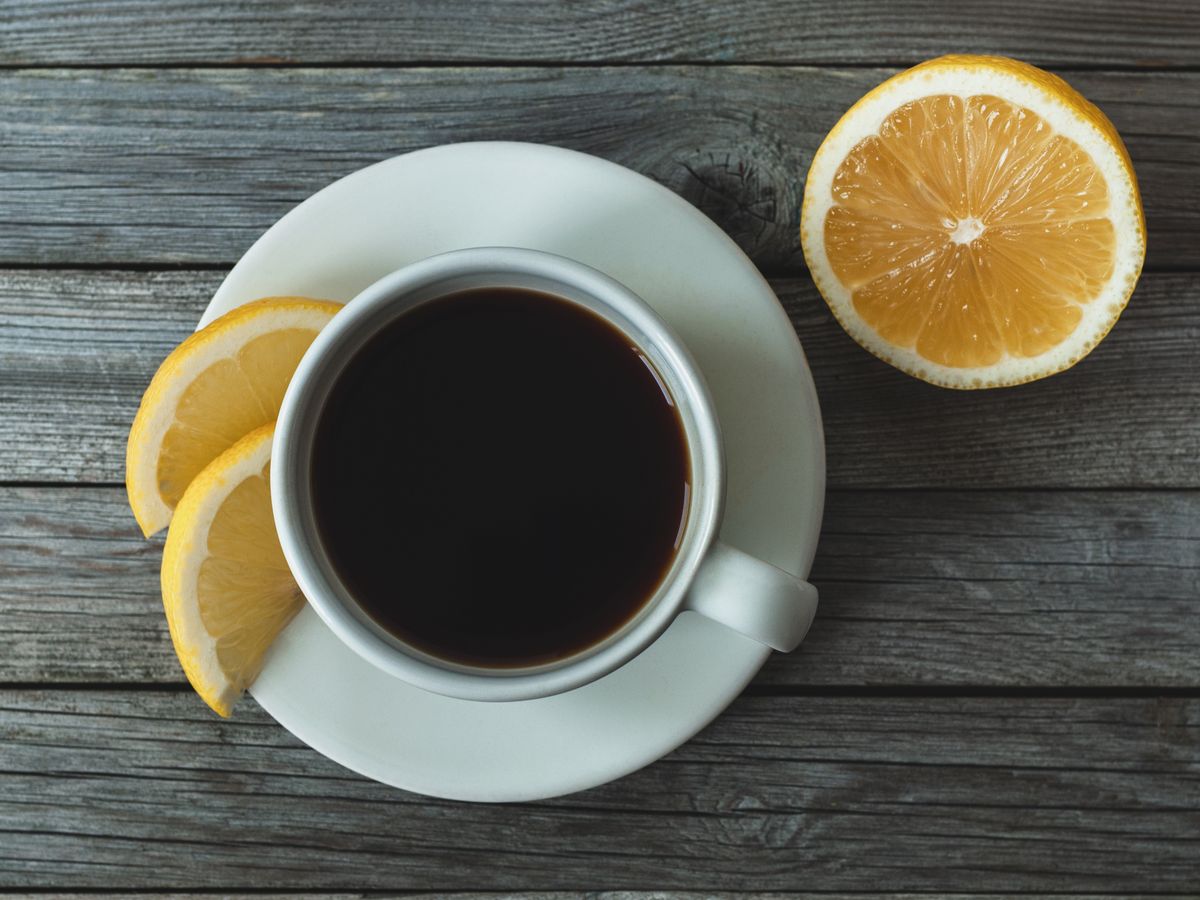 https://hips.hearstapps.com/hmg-prod/images/coffee-with-lemon-on-gray-wooden-background-table-royalty-free-image-1683936122.jpg?crop=0.89256xw:1xh;center,top&resize=1200:*