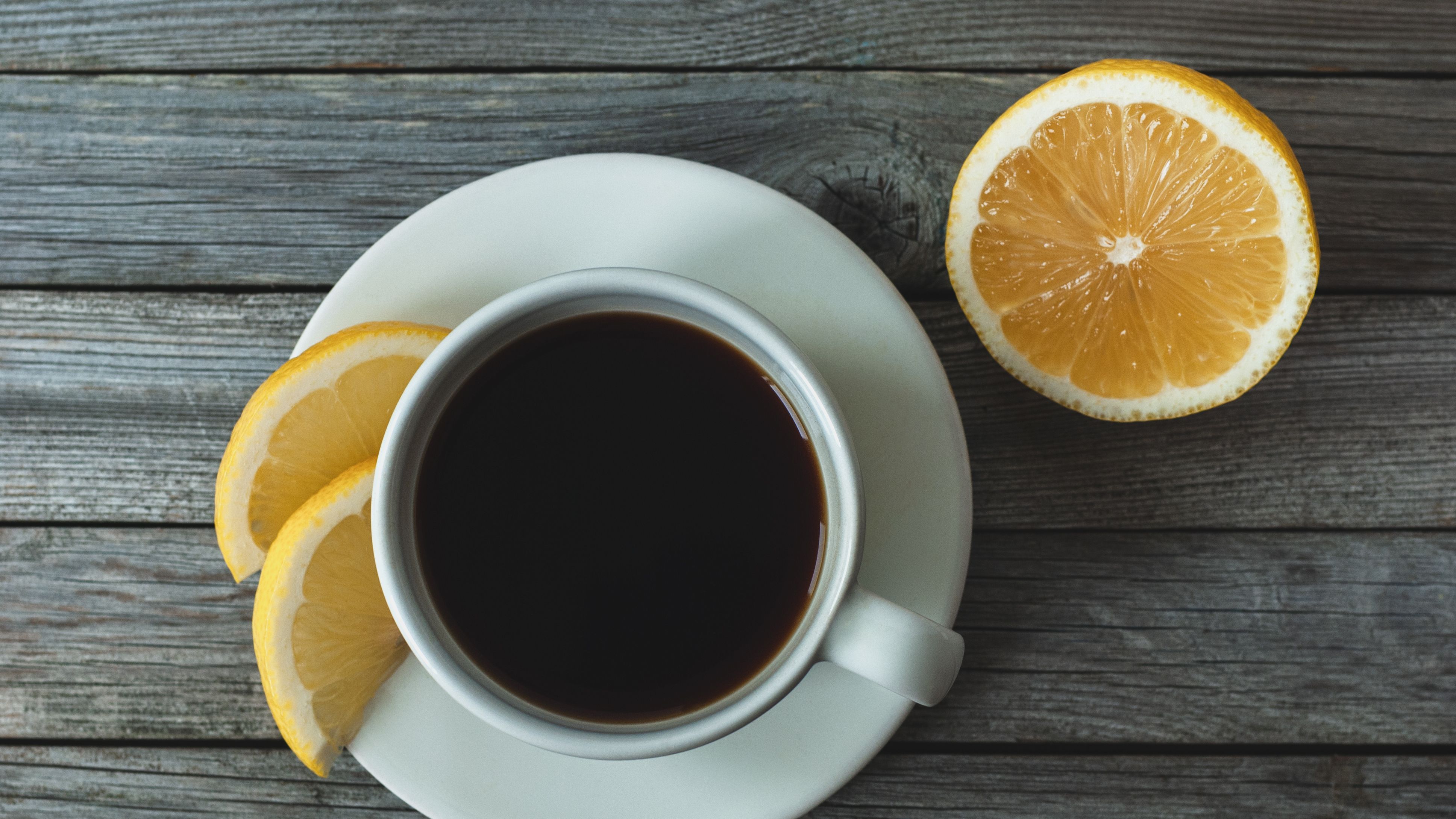 https://hips.hearstapps.com/hmg-prod/images/coffee-with-lemon-on-gray-wooden-background-table-royalty-free-image-1695223028.jpg?crop=1xw:0.84028xh;center,top