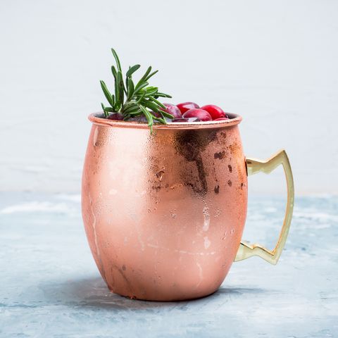cold christmas moscow mule cocktail in copper mug on the rustic background