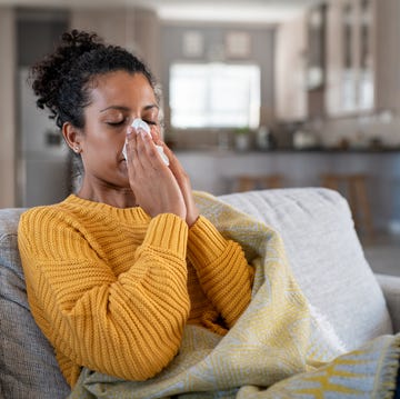 cold sick african woman blowing nose