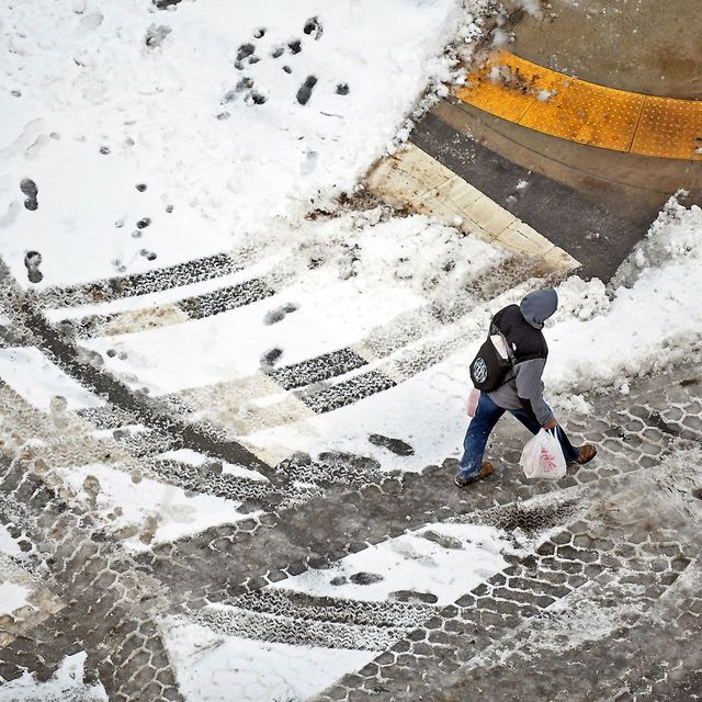 Een voetganger steekt op 20 januari de straat over in het centrum van Scranton in de Amerikaanse staat Pennsylvania nadat een winterstorm een groot deel van de VS met een laag sneeuw bedekte en enkele van de laagste temperaturen van het seizoen werden gemeten Het winterweer ontregelde het luchtverkeer en zorgde voor gladde wegen in de hele staat New England