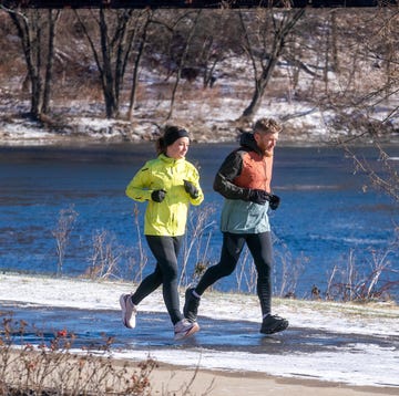 Two individuals jogging along a snowy riverside path two individuals jogging along a snowy riverside path