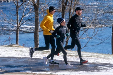group of three individuals jogging in a winter setting