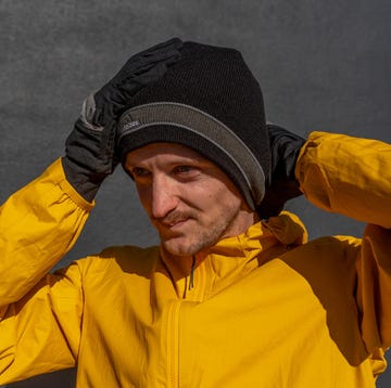 Individual wearing a yellow jacket and black gloves appearing to express an emotion individual wearing a yellow jacket and black gloves appearing to express an emotion