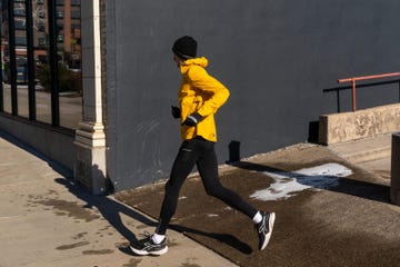 person running outdoors in athletic attire aside a city building
