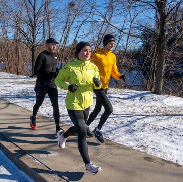 group of runners jogging on a snowy path beside a river group of runners jogging on a snowy path beside a river