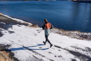 runner on a snowcovered path beside a body of water