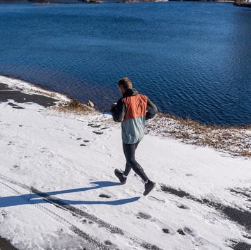 Runner on a snowcovered path beside a body of water runner on a snowcovered path beside a body of water