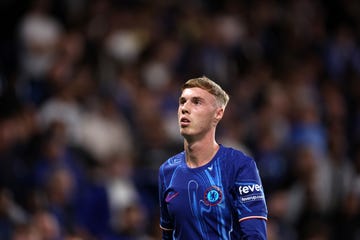 chelsea footballer cole palmer looks upwards as he stands in a stadium during a football match