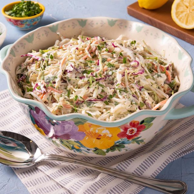 coleslaw in pw bowl with spoon and lemons in back