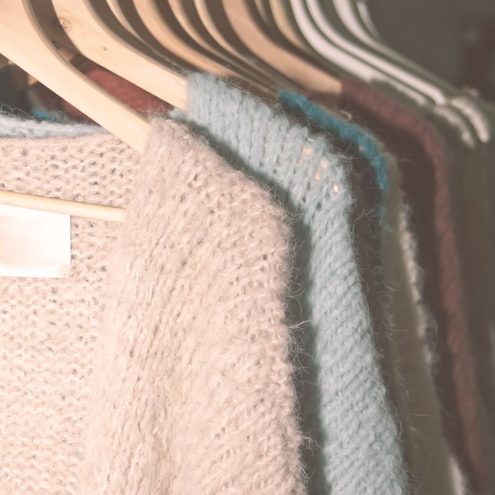 collection of warm woman's sweaters hanging on rack