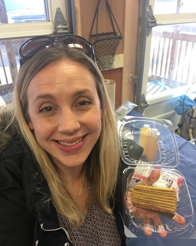 author, colleen holding a slice of smith island layer cake