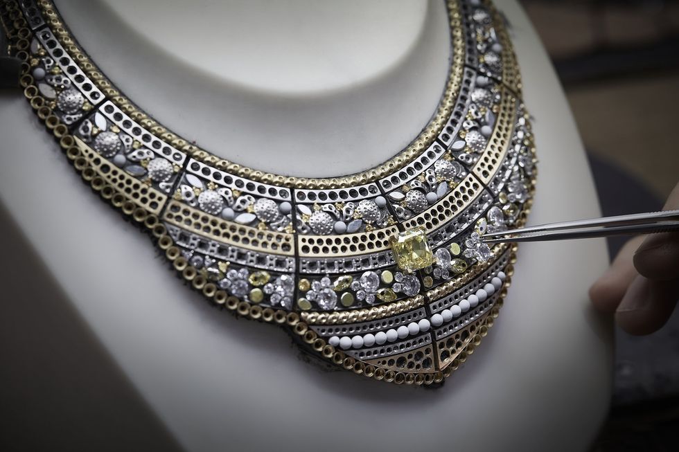 扭索紋纜繩飾邊如古董珠寶般優雅細緻，中央鑲嵌一顆重約9.50克拉正方祖母綠形切割艷彩黃鑽