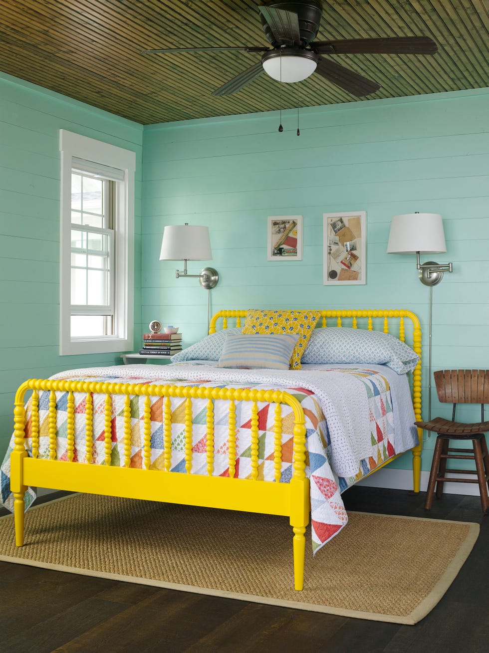 bedroom with seafoam walls and bright yellow spool bed