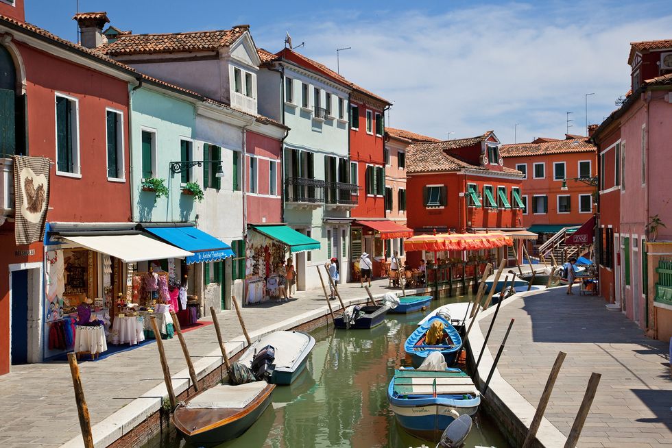 colorful boats and homes lining canal in burano, venice