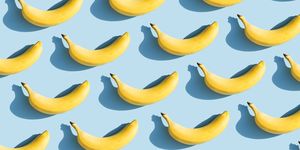 colorful fruit pattern of fresh yellow bananas on blue background with shadows