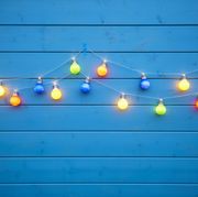 colorful string lights for party decoration at a blue painted wooden wall