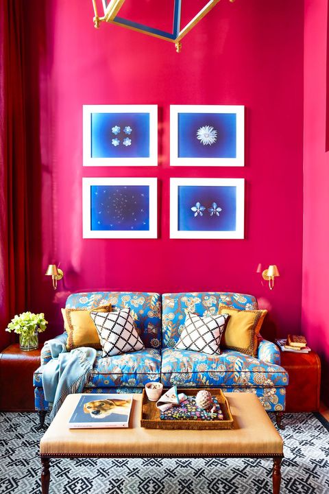 hot pink living room with blue sofa and art