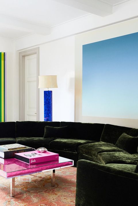 modern living room with pink coffee table green sofa and blue art