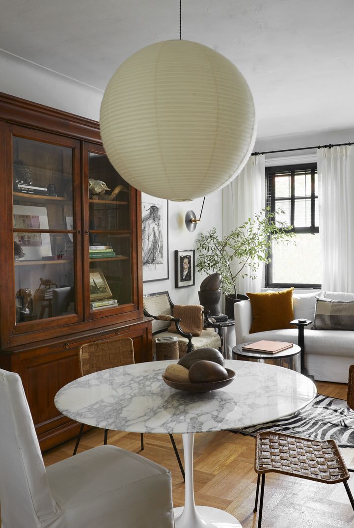david frazier nyc apartment
living room
with limited space in this new york
city apartment, designer david frazier
divided the living room into two
distinct zones lounging and eating
paint simply white, benjamin
moore dining table eero saarinen,
knoll chairs lee industries
slipper vintage french rattan
vintage kaare klint safari
pendant isamu noguchi bookcase
scott antique markets ram’s
head vintage, high point market